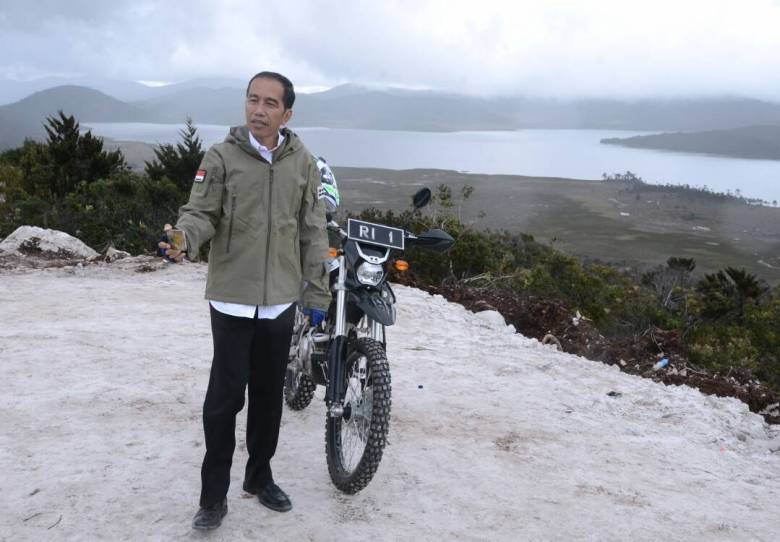 Indonesian President Joko Widodo posing with his motorbike as he embarks with a delegation to get a first hand look at the proposed Trans-Papua highway, from Wamena in the insurgency-hit region of Papua. Photo: AFP/Indonesian Presidential Palace Handout 